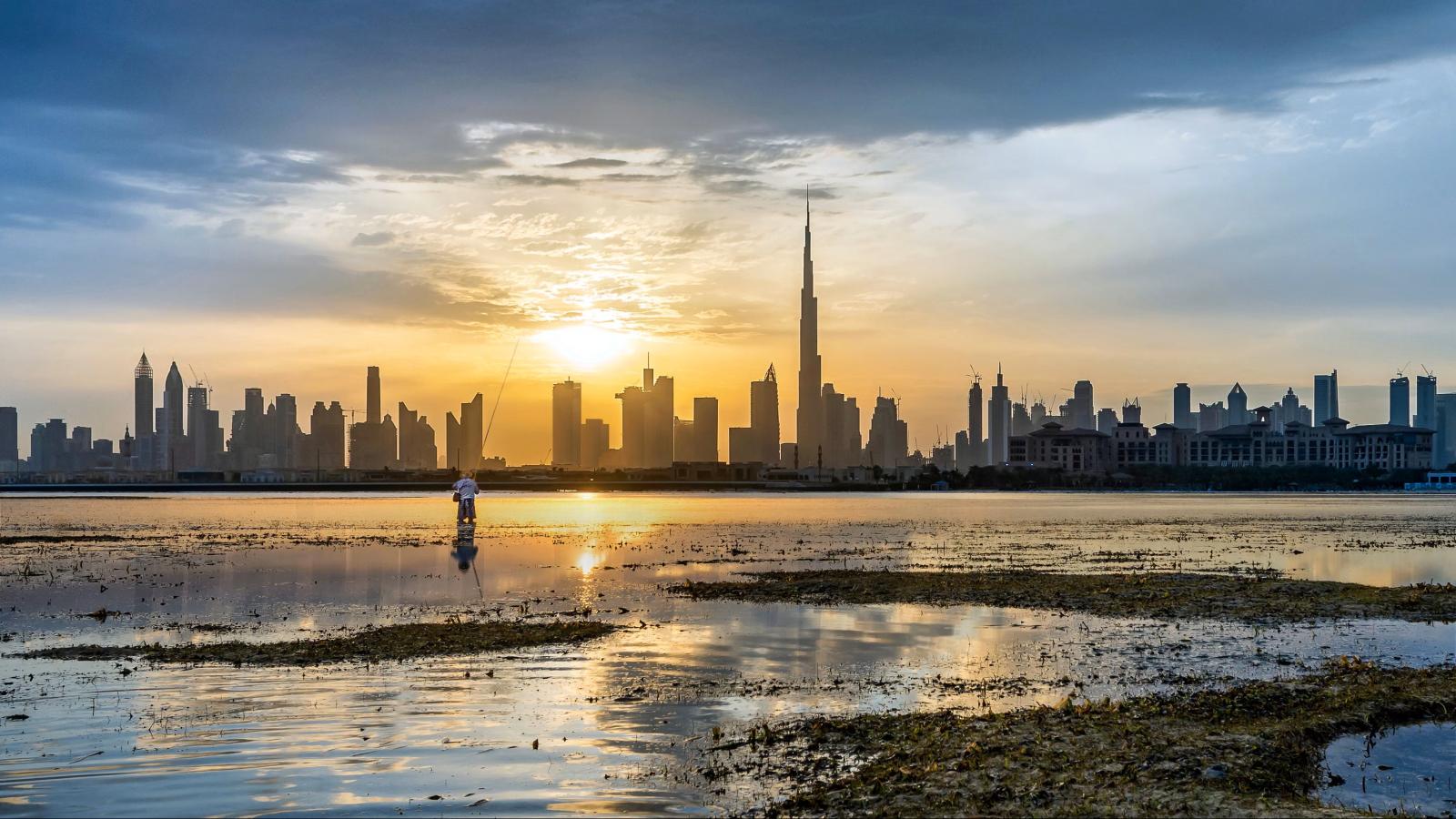 Dubai Skyline mit Burj Khalifa und Meer bei Sonnenuntergang
