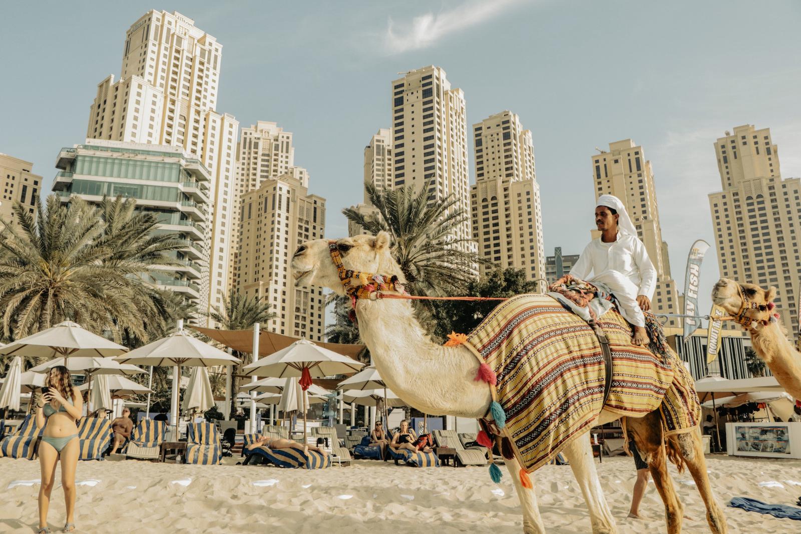 Sandstrand in Dubai mit Palmen und moderner Skyline