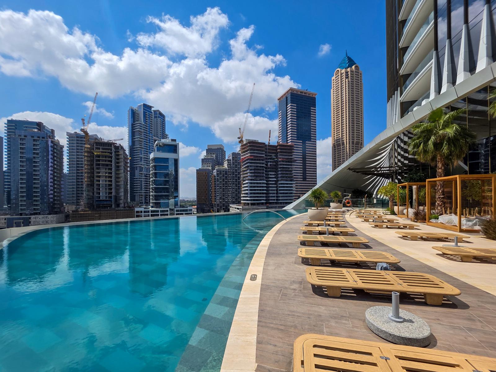 Luxushotel in Dubai mit Pool und Skyline im Hintergrund
