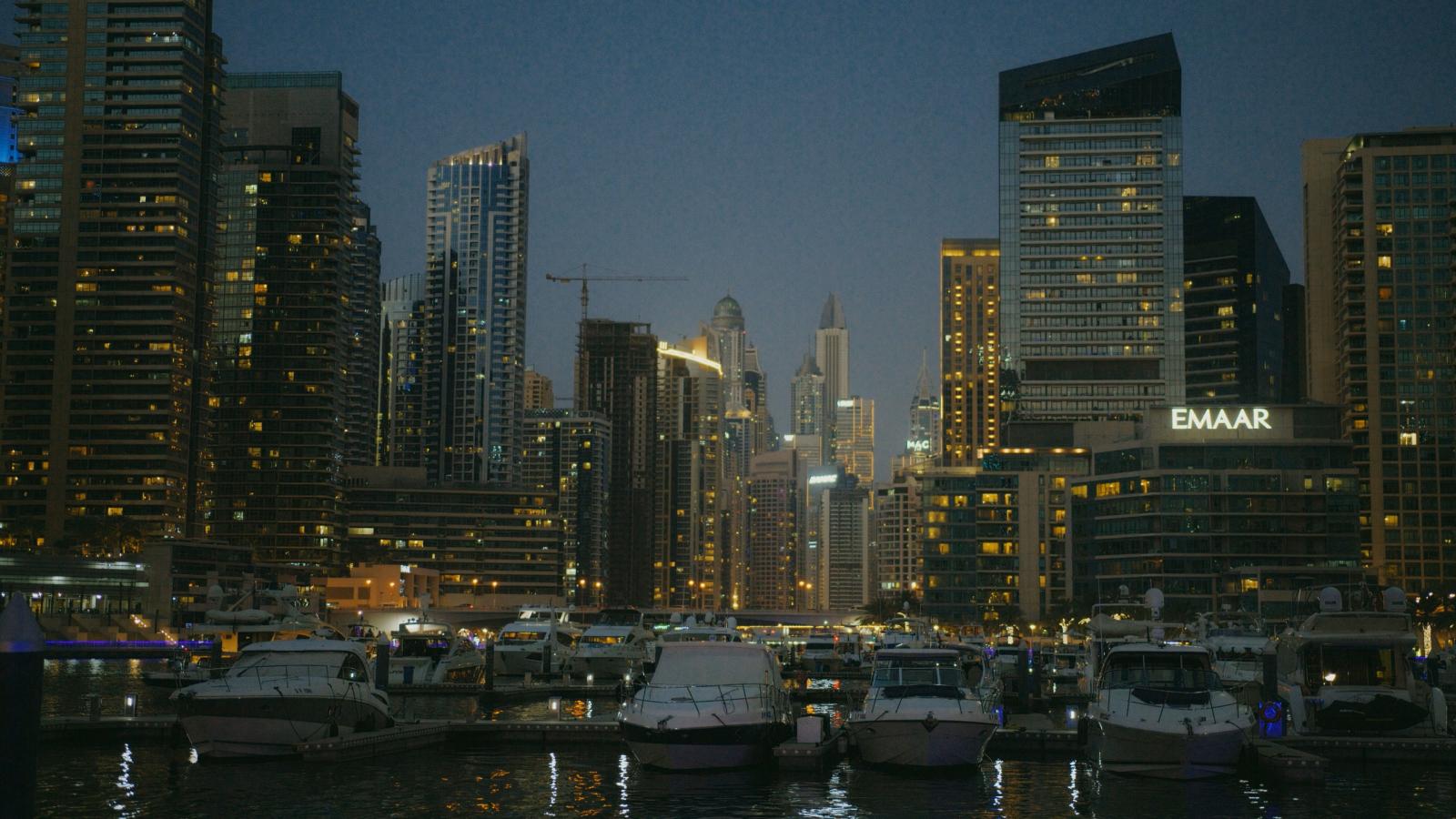 Dubai Marina bei Nacht mit beleuchteter Skyline und Yachten