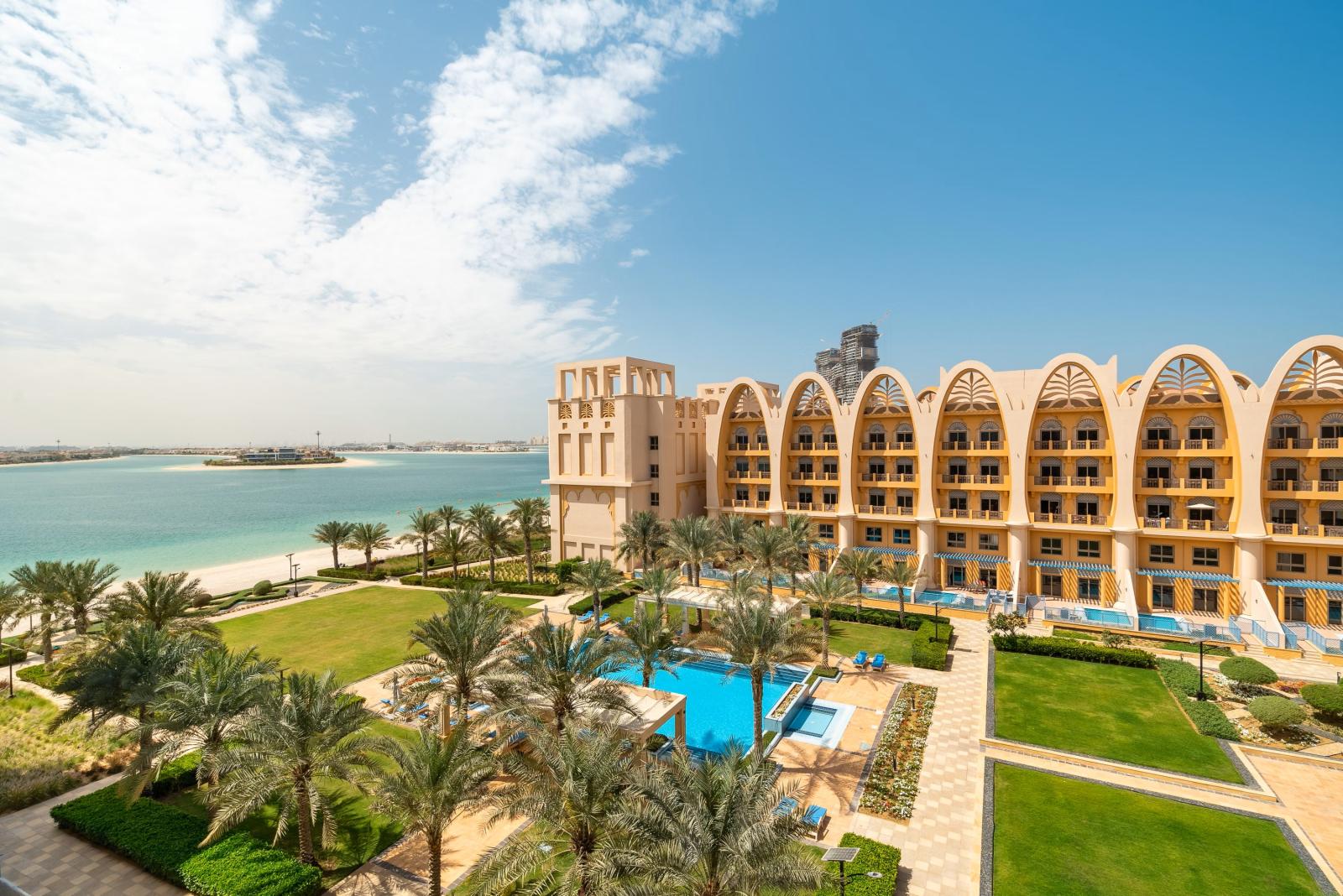 Strandhotel in Dubai mit Palmen, Pool und Meerblick