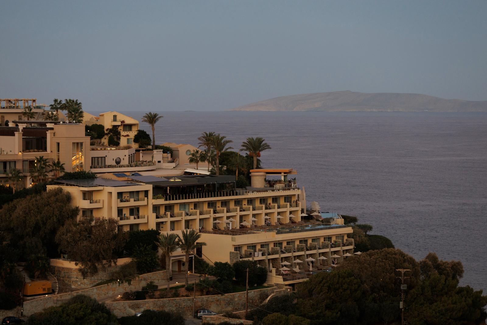 BLICK AUF EIN GRIECHISCHES HOTEL MIT MEER UND SONNENUNTERGANG]