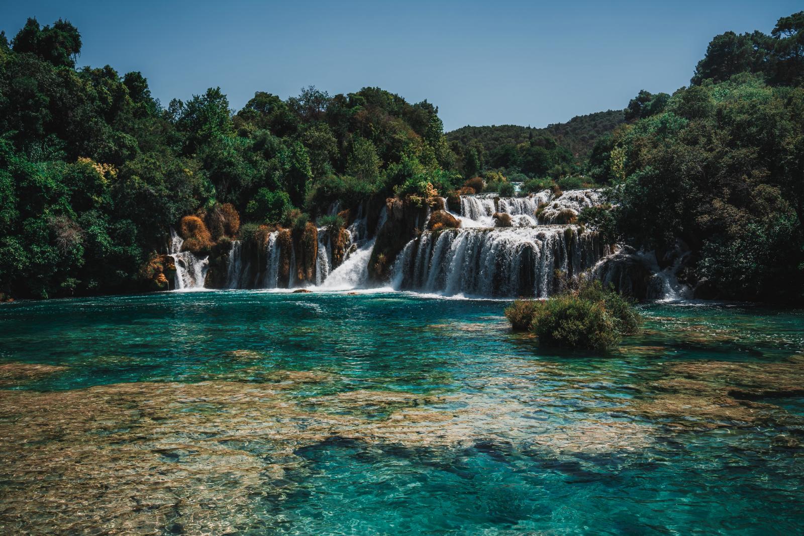 Wasserfall im Nationalpark Krka mit türkisfarbenem Wasser und üppiger grüner Vegetation
