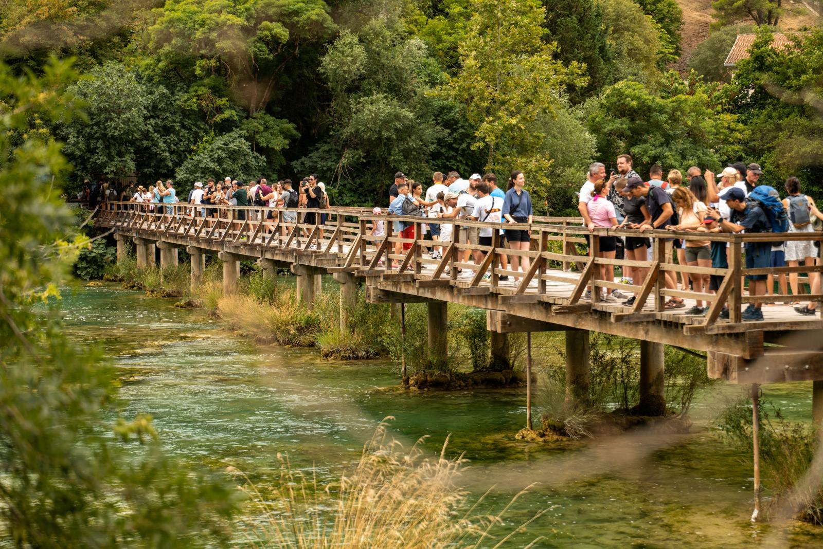  Familie oder Besucher auf einem Weg durch die Natur des Nationalparks Krka]