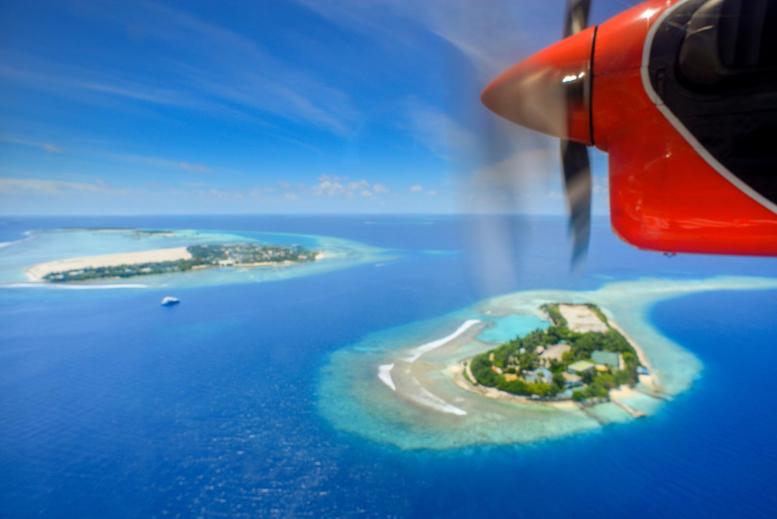 Wasserflugzeug über einer Lagune mit Blick auf mehrere Inseln