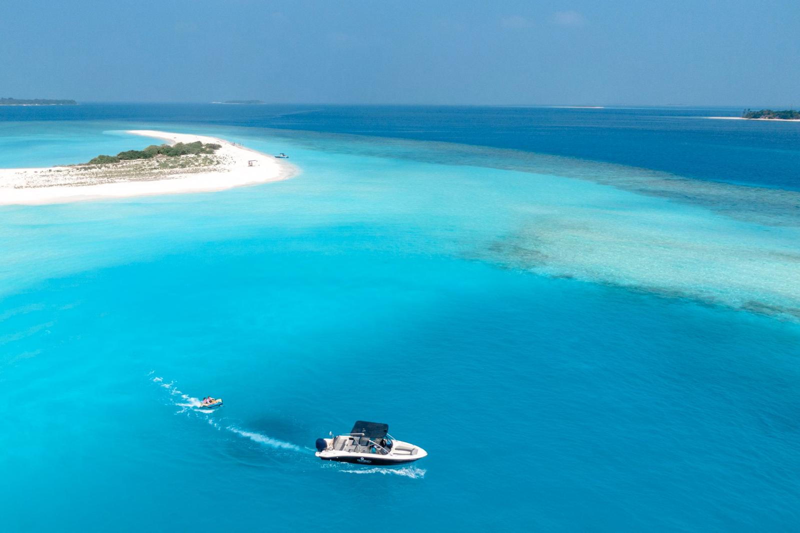 Schnellboot vor einer tropischen Insel mit türkisfarbenem Wasser