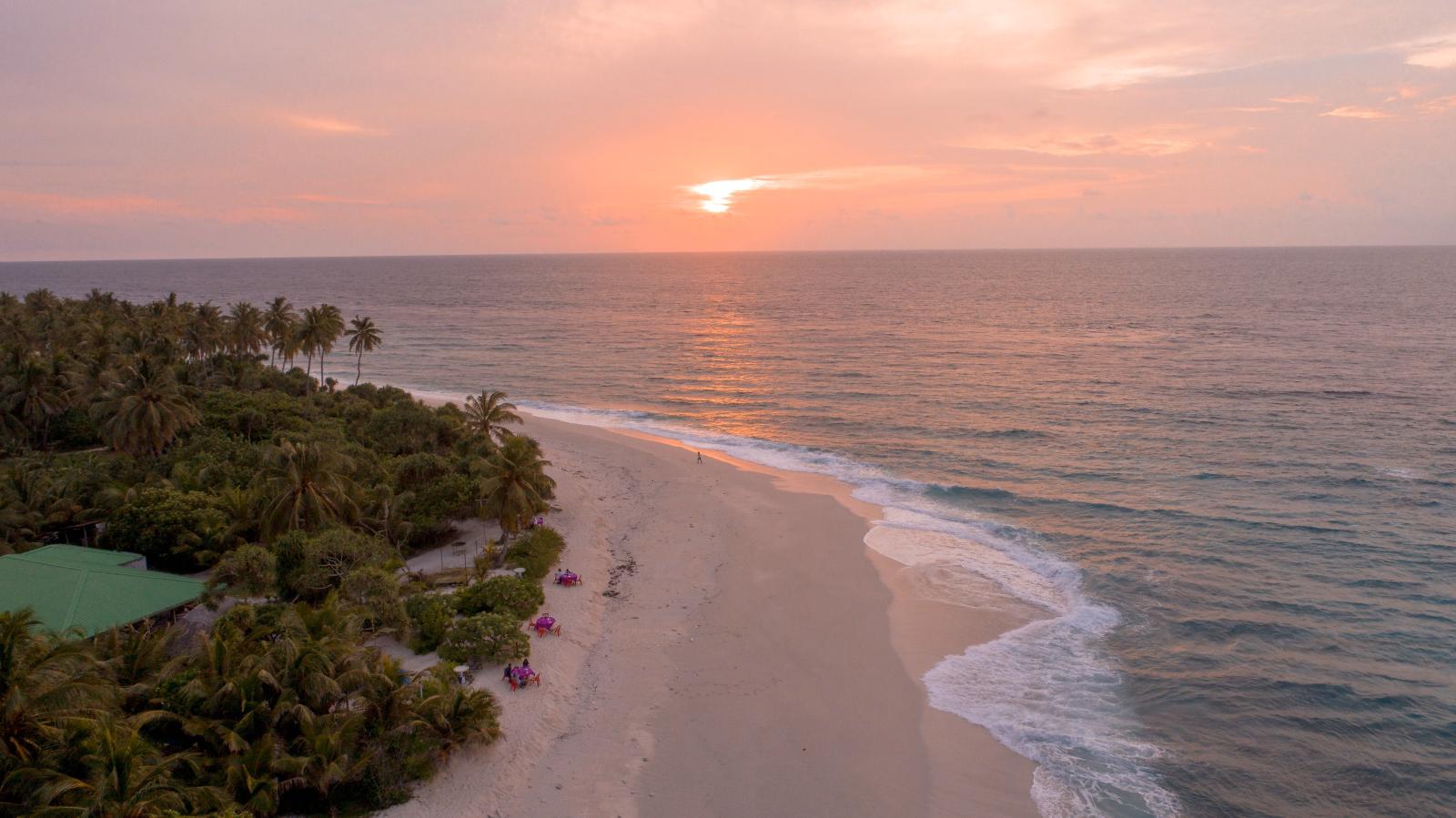  Abendliches Licht über dem Indischen Ozean mit Palmen am Sandstrand]