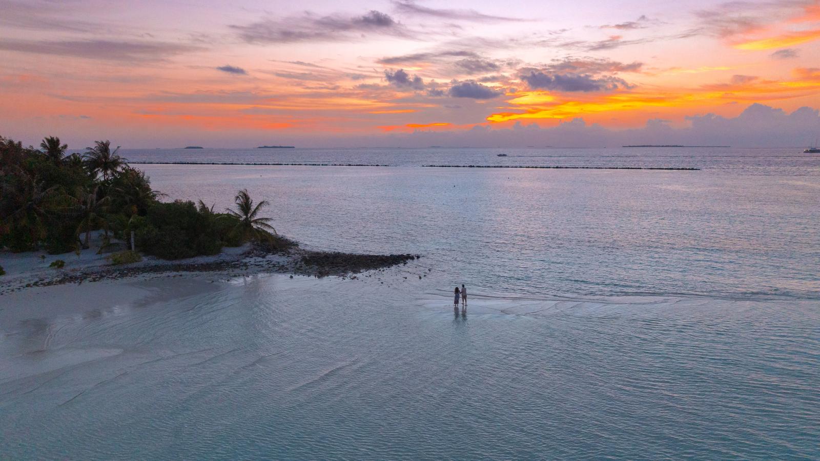 Warmer Abendhimmel über dem Indischen Ozean mit einer Insel im Hintergrund