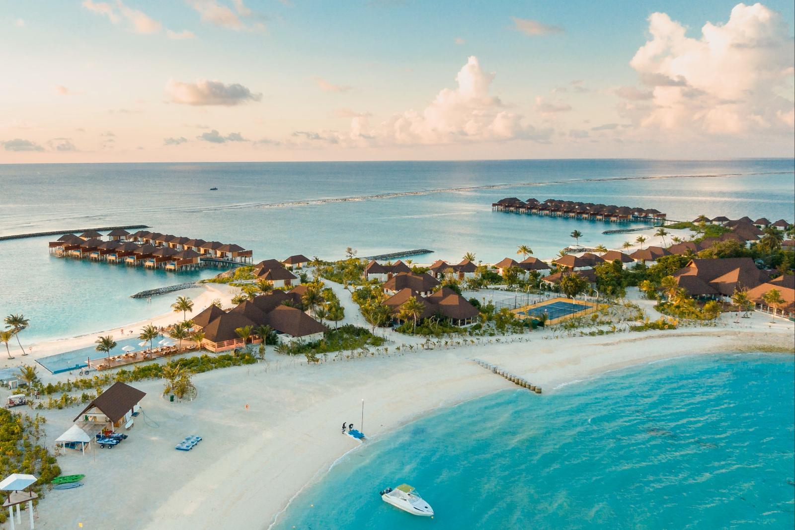 Tropische Hotelinsel mit Palmen, Strand und türkisfarbener Lagune