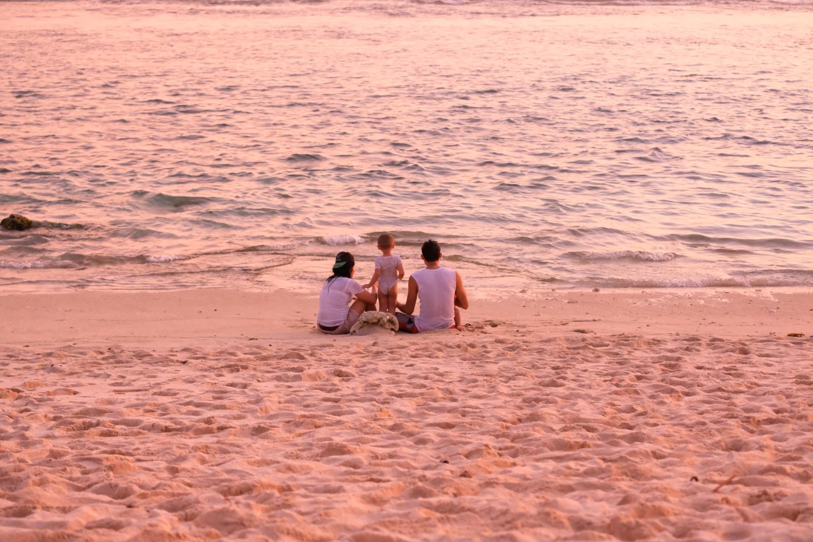 Familie genießt den Sonnenuntergang am Strand einer Malediveninsel