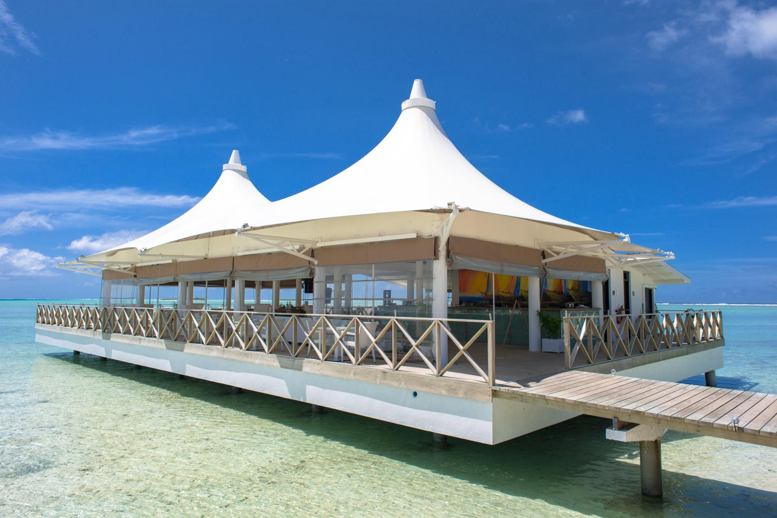 Resortrestaurant mit Blick auf eine türkisfarbene Lagune