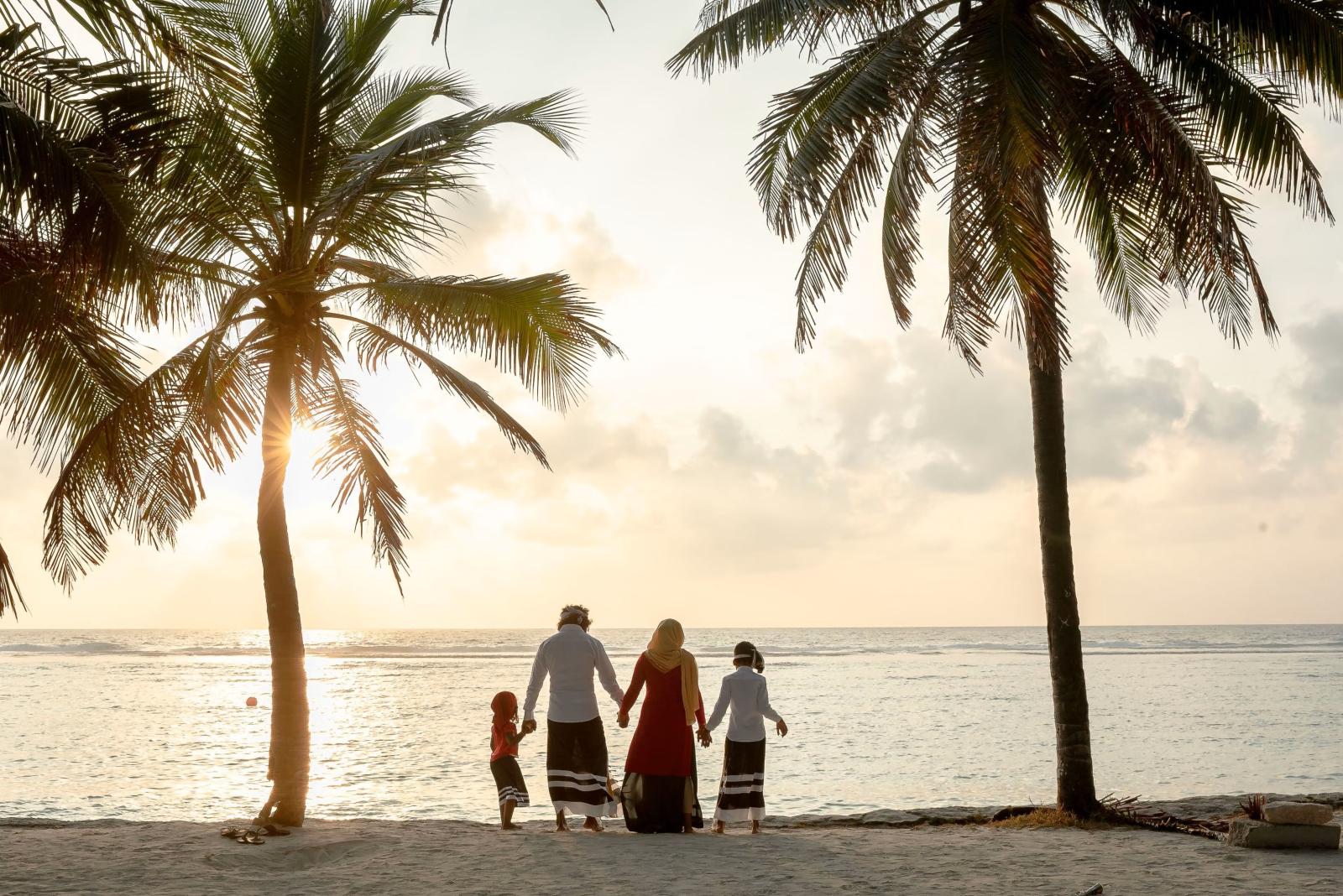Familie am ruhigen Strand mit Blick auf eine türkisfarbene Lagune