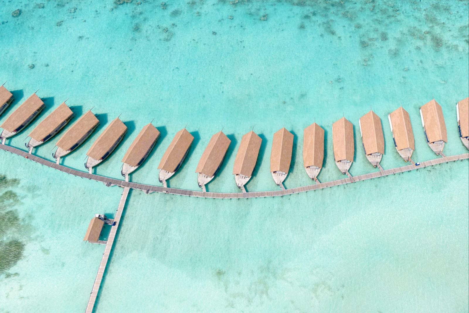 Luftaufnahme von Wasserbungalows entlang einer geschwungenen Lagune