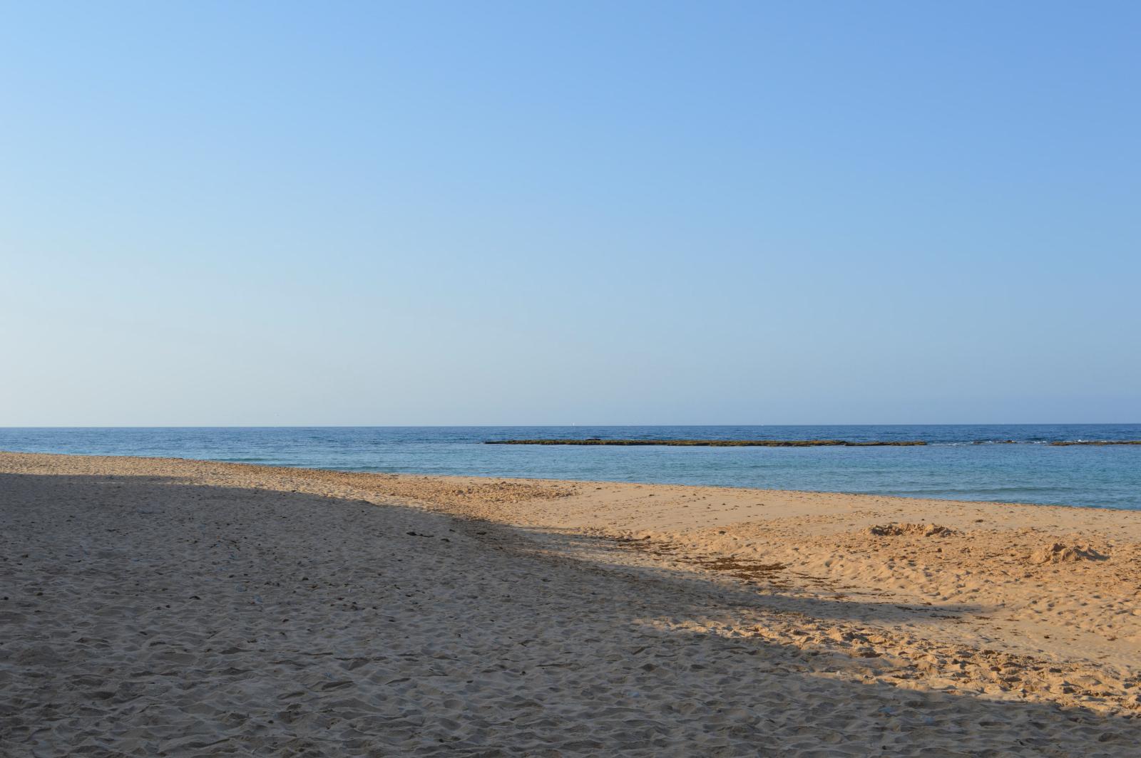 Weitläufiger Sandstrand im Norden Maltas mit ruhigem Meer