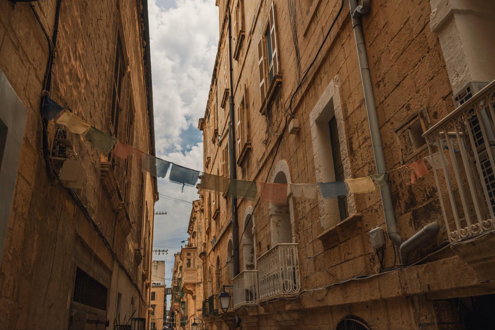 Historische Gasse in Malta mit traditionellen Balkonen und hellem Naturstein