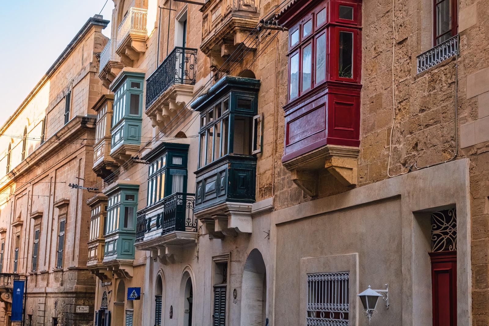 Historische Gasse in Valletta mit hellen Kalksteinfassaden und traditionellen Balkonen