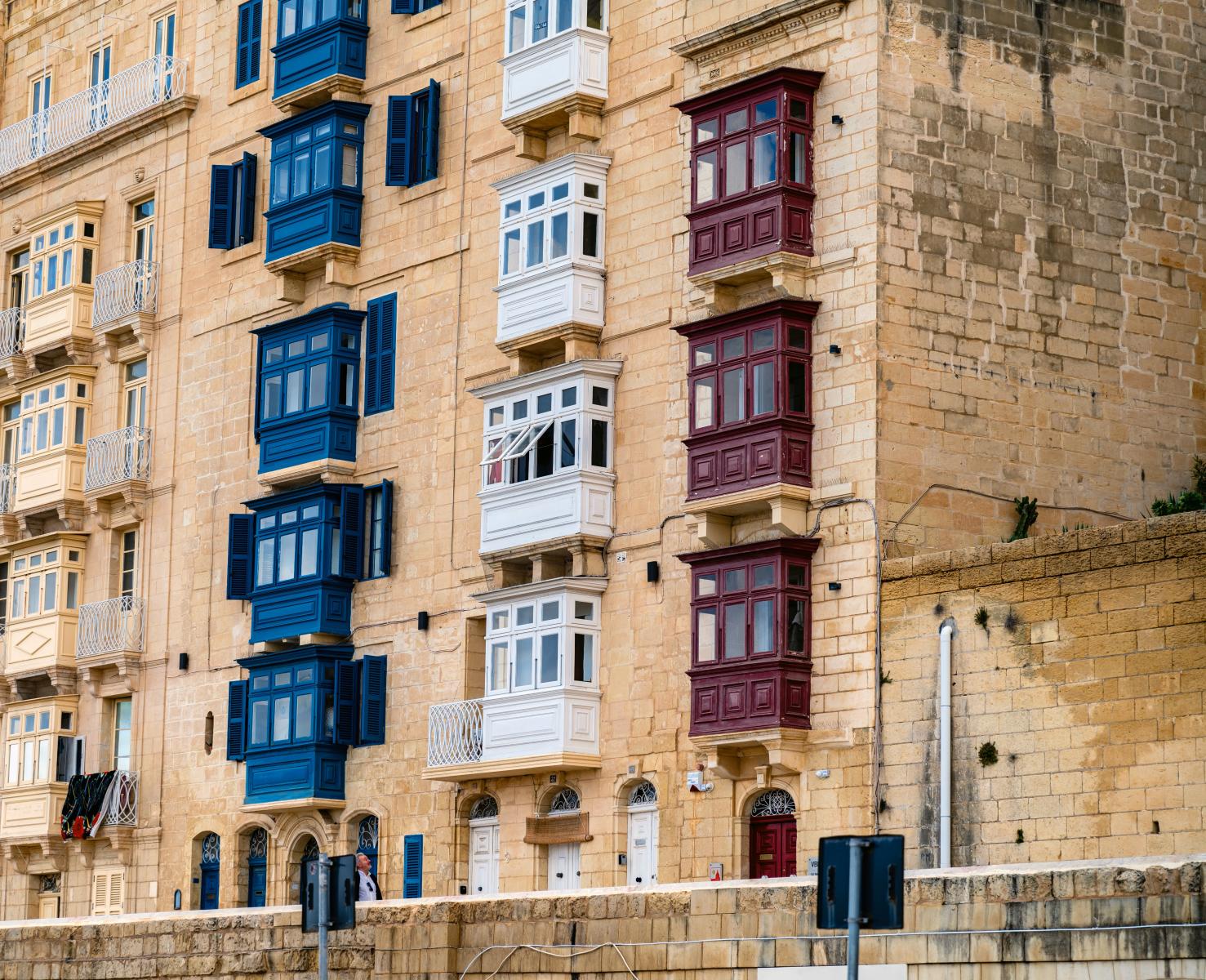 Lebendige maltesische Balkone an historischen Steingebäuden in Valletta, Malta. Klassische mediterrane Architektur.