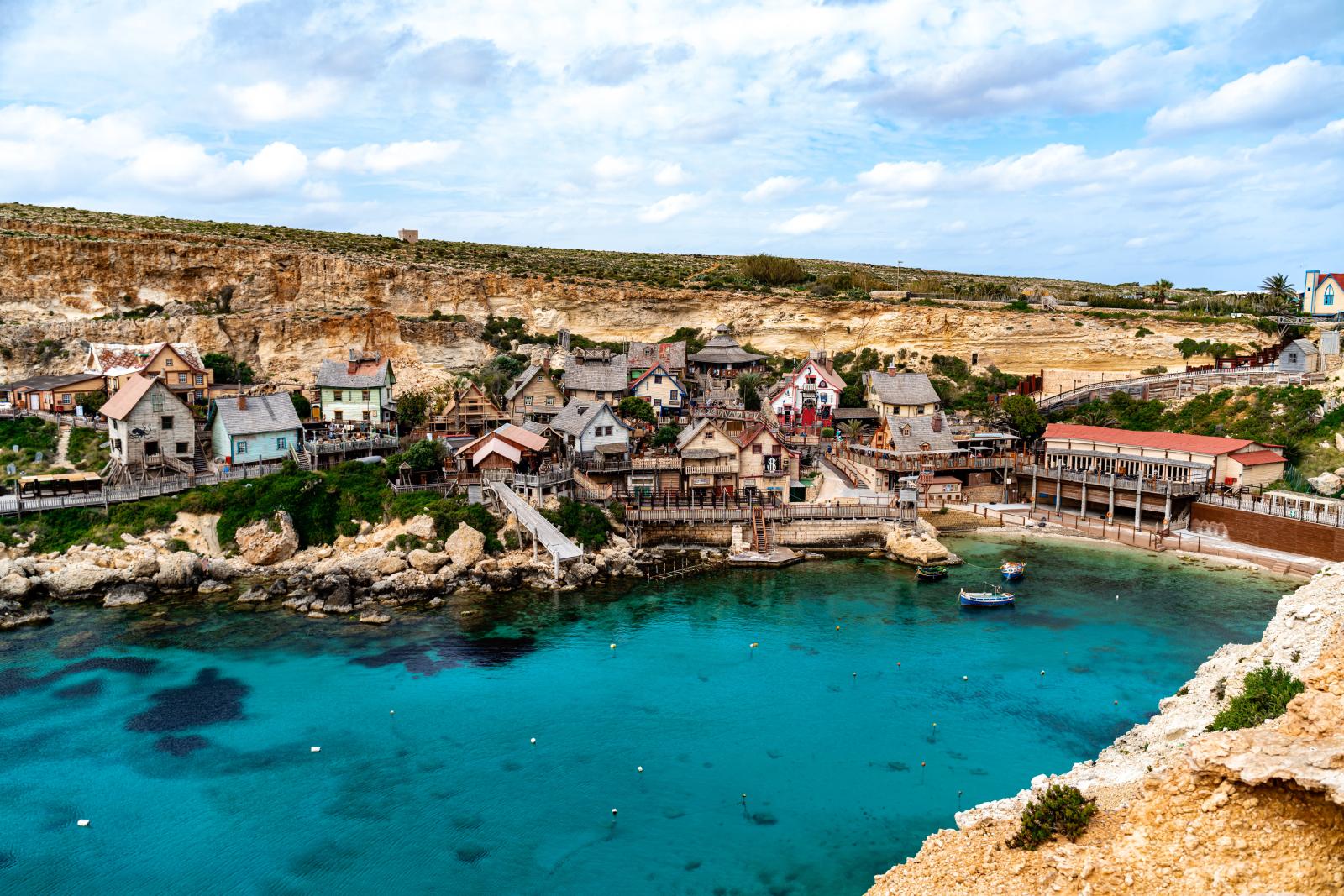 Blick über Mellieħa mit Häusern, Pfarrkirche und mediterraner Landschaft