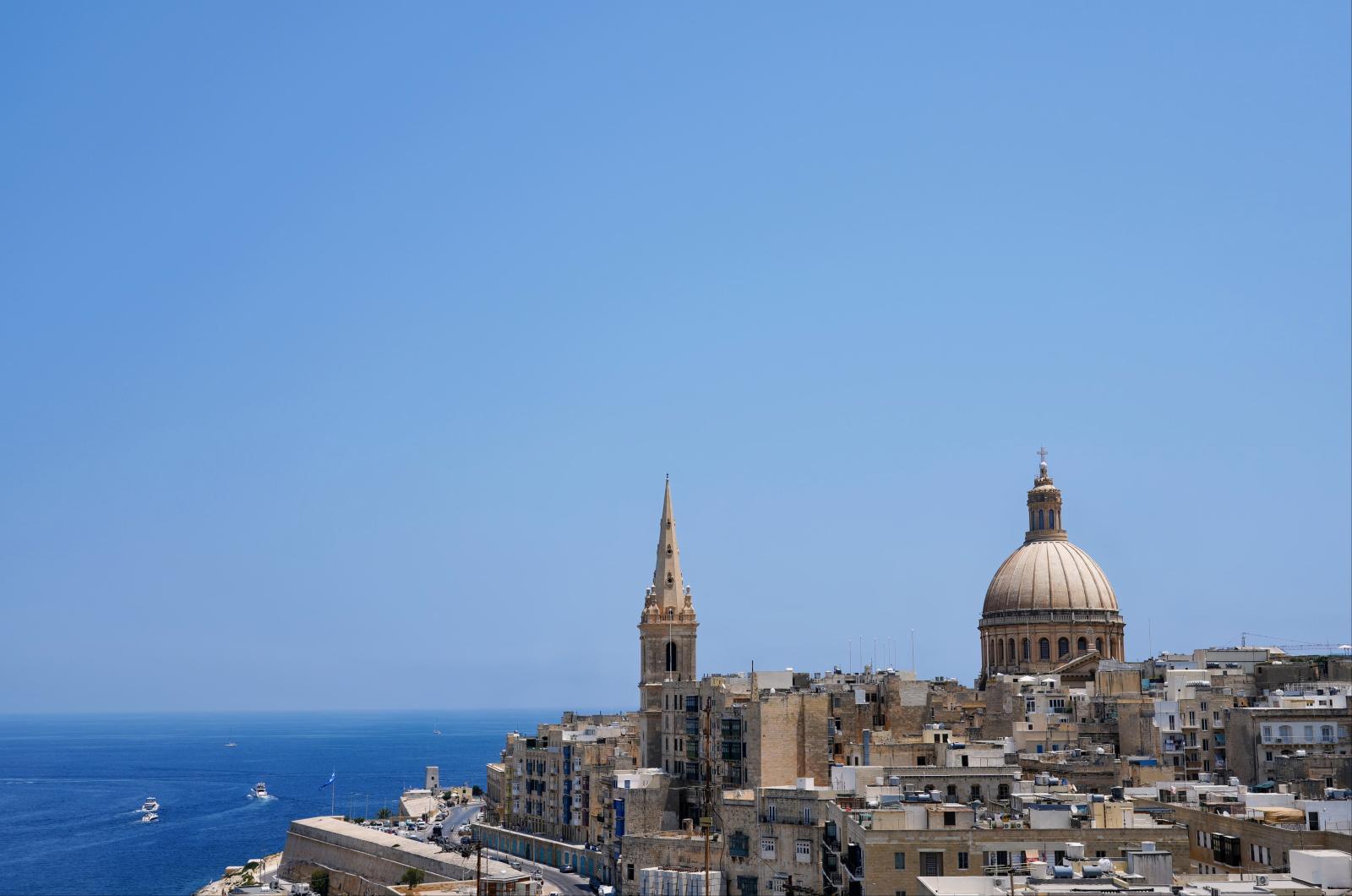 Blick über Maltas Küste mit historischen Gebäuden und dem Mittelmeer