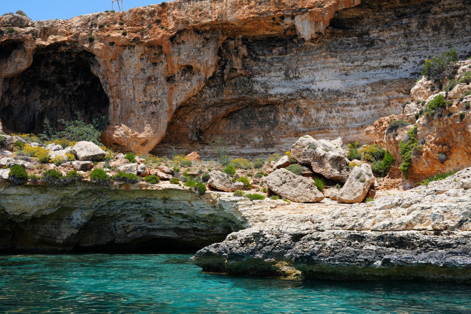 Blaue Grotte an der Südküste Maltas mit türkisblauem Wasser]