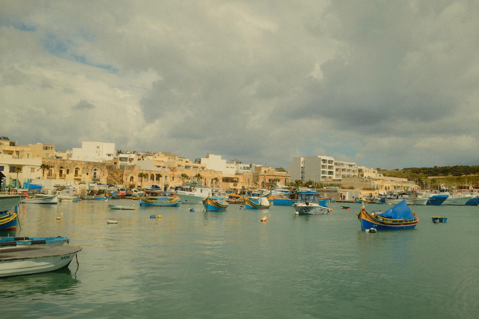Blick von der Uferpromenade auf die bunten Boote und Häuser von Marsaxlokk