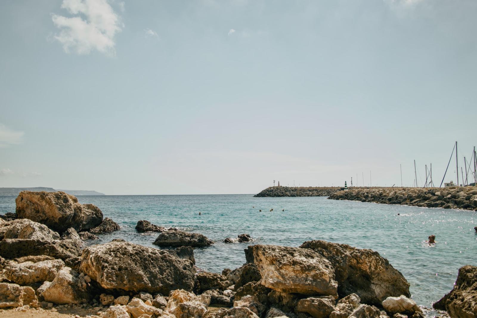 Küstenlandschaft auf Gozo mit steilen Felsen und tiefblauem Meer]