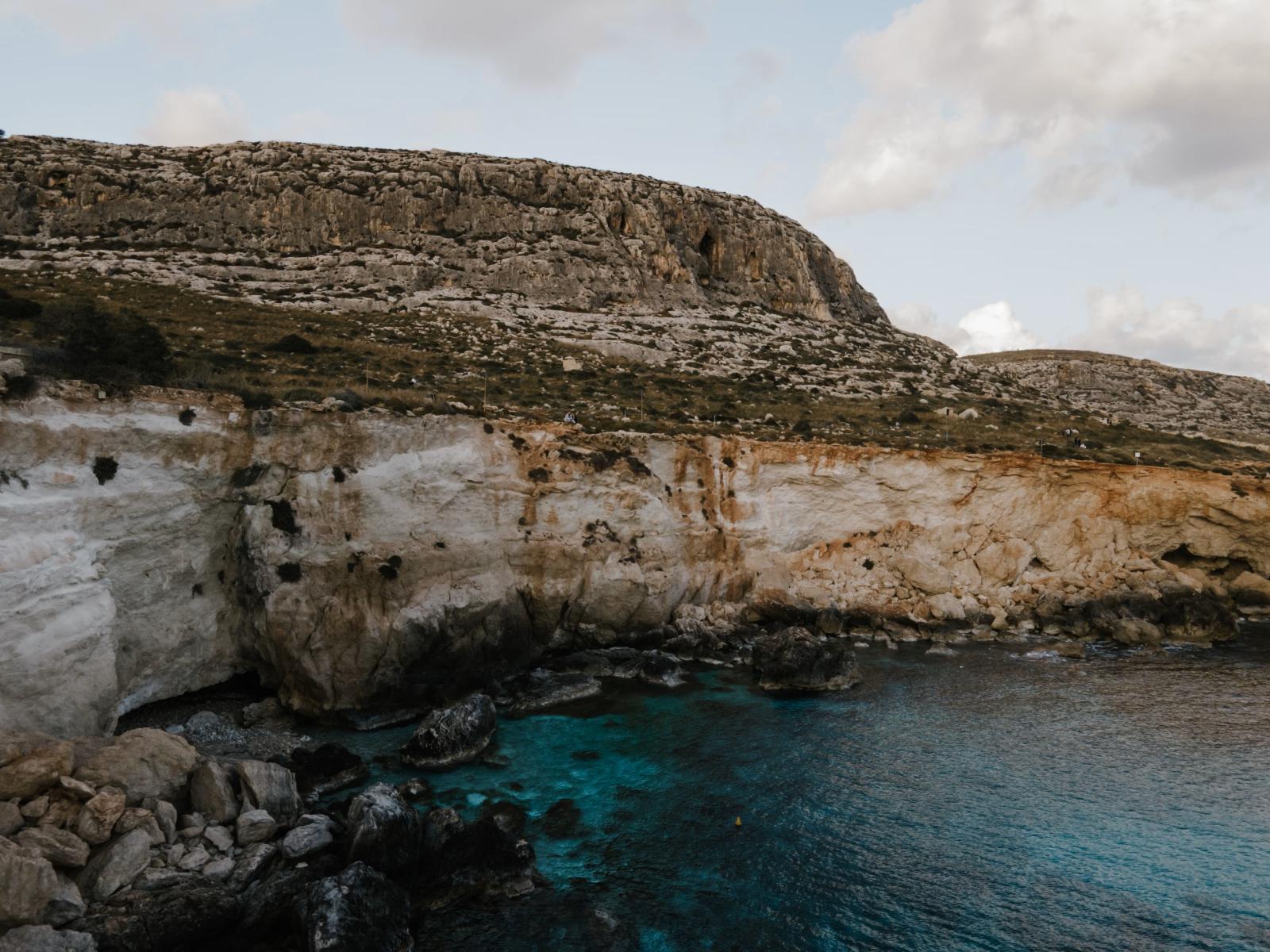 Ein atemberaubender Blick auf die felsigen Klippen und das türkisfarbene Wasser entlang der Küste von Siggiewi, Malta.