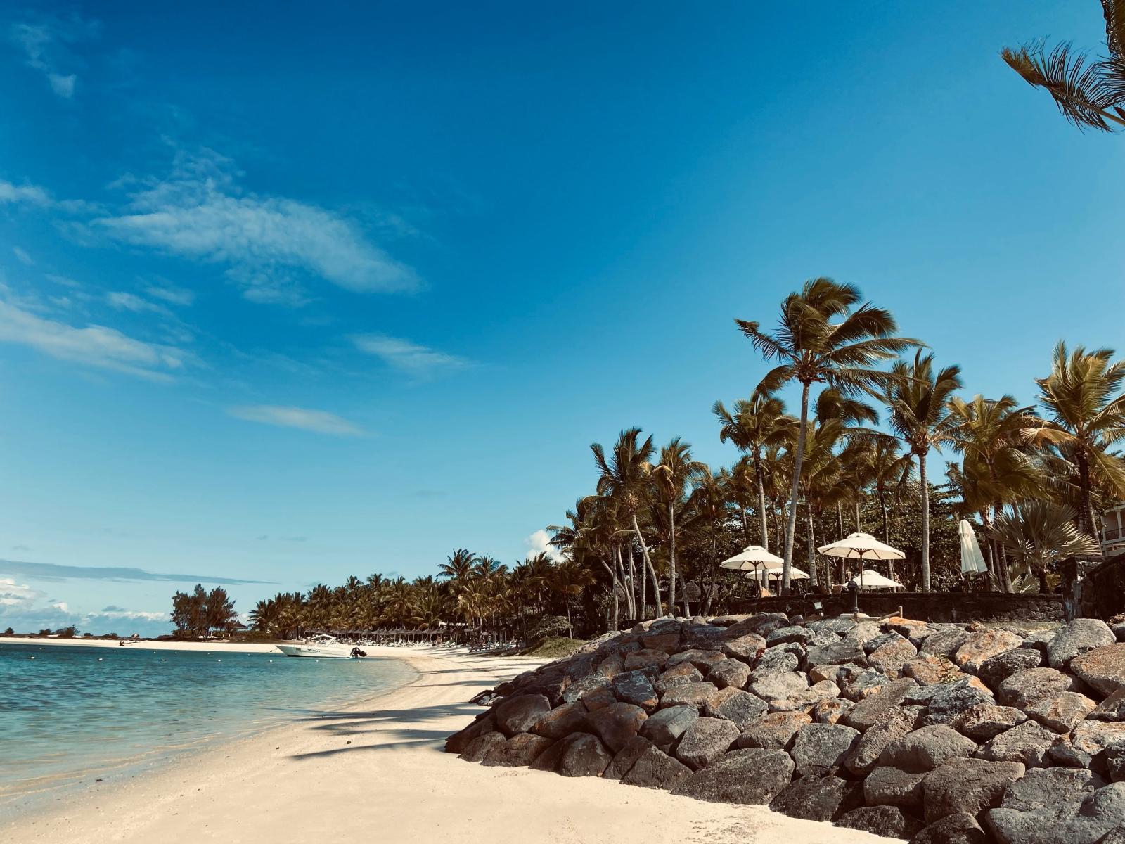 Tropisches Strandresort auf Mauritius mit Palmen, türkisfarbener Lagune und hellem Sandstrand.