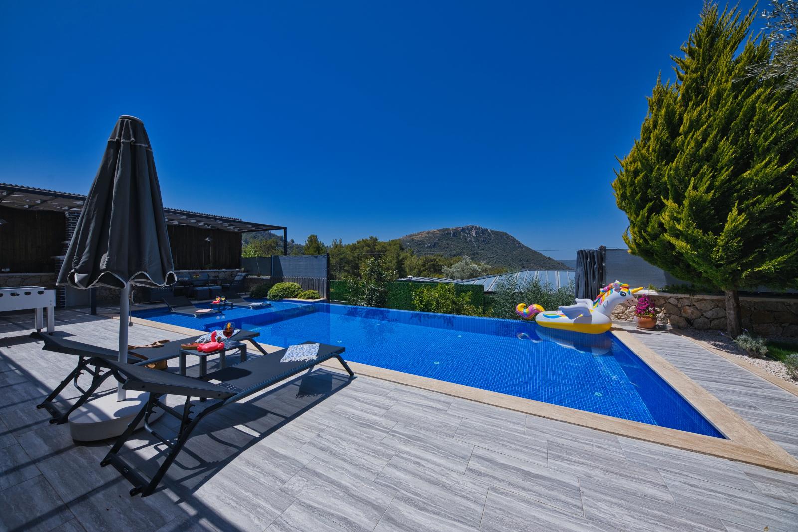 Private Poolvilla in einer tropischen Gartenanlage mit stilvoller Terrasse und Blick ins Grüne.