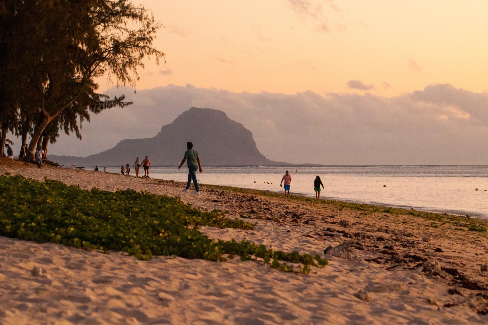 Sonnenuntergang über einem Strand auf Mauritius mit Palmensilhouetten