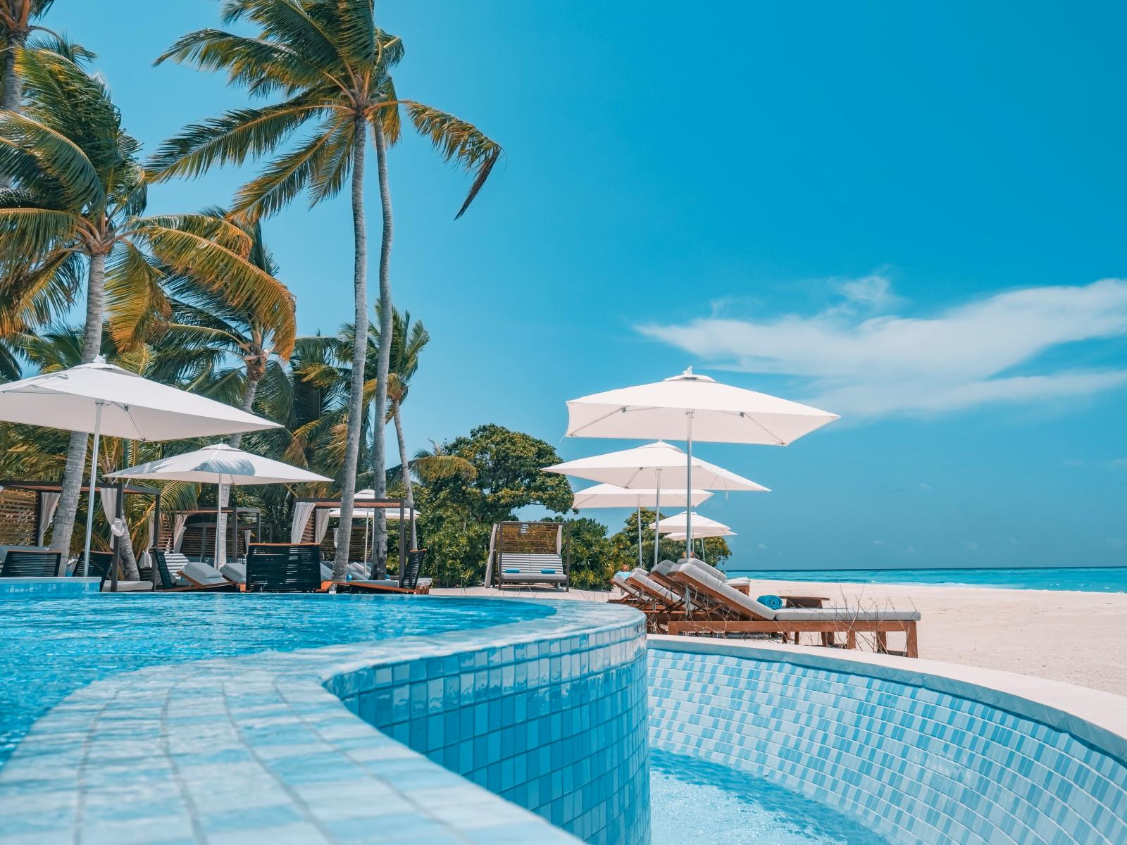 Exklusives Strandresort auf Mauritius mit Infinity-Pool, Palmen und türkisfarbener Lagune.