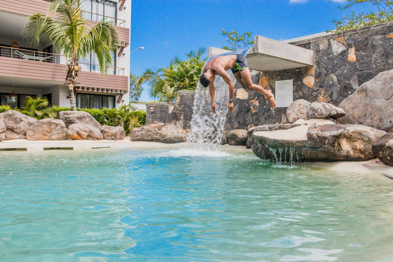 Resortpool mit Palmen, Sonnenliegen
