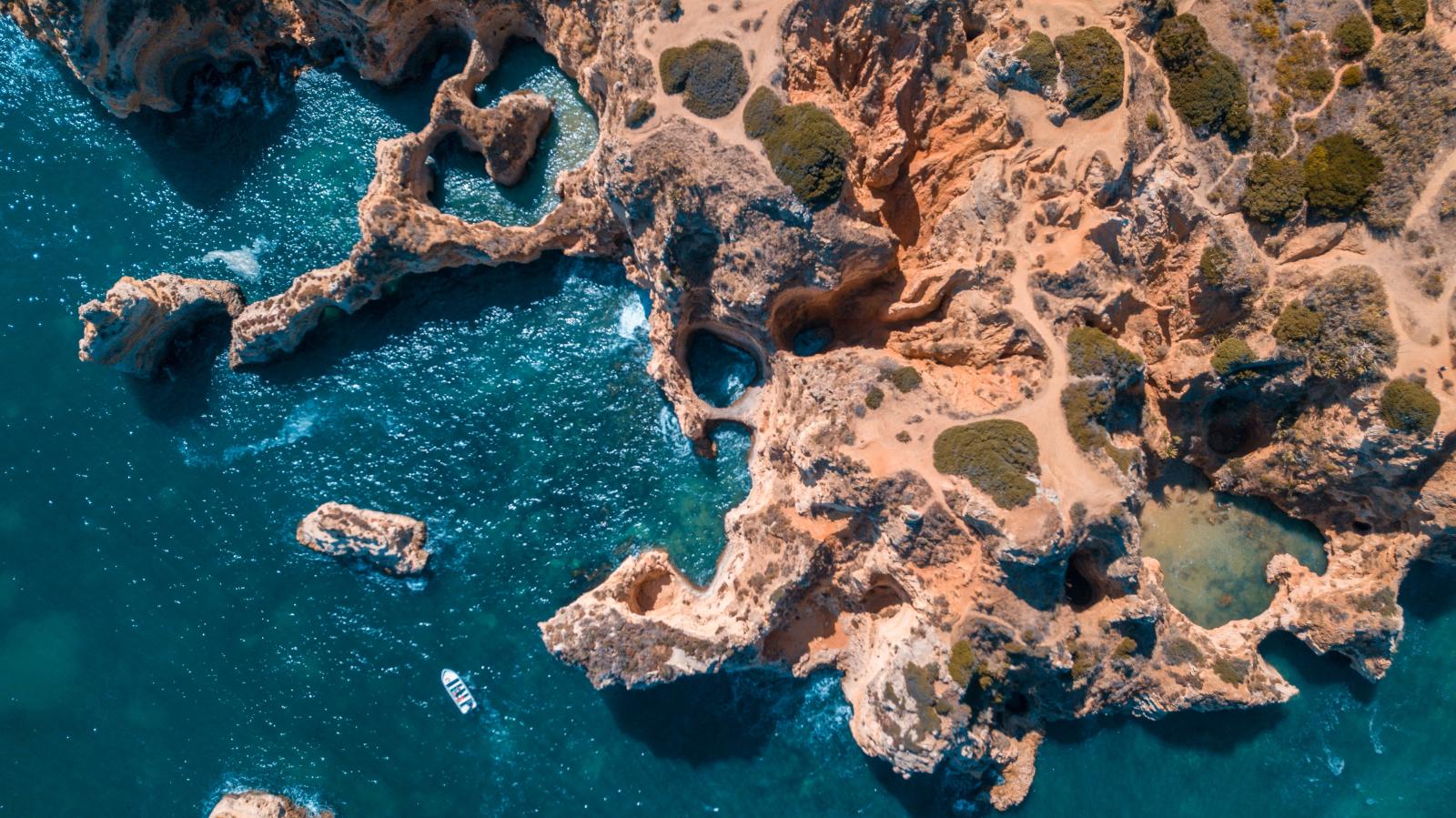 Ausflugsboot vor einer Felsenküste an der Algarve