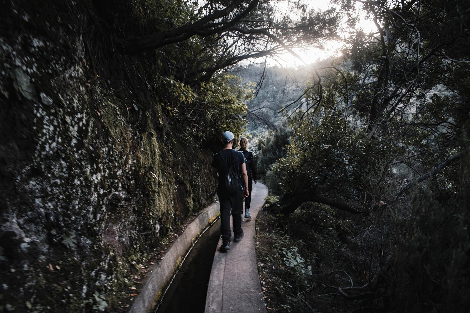 Wanderweg entlang einer Levada durch die grüne Berglandschaft