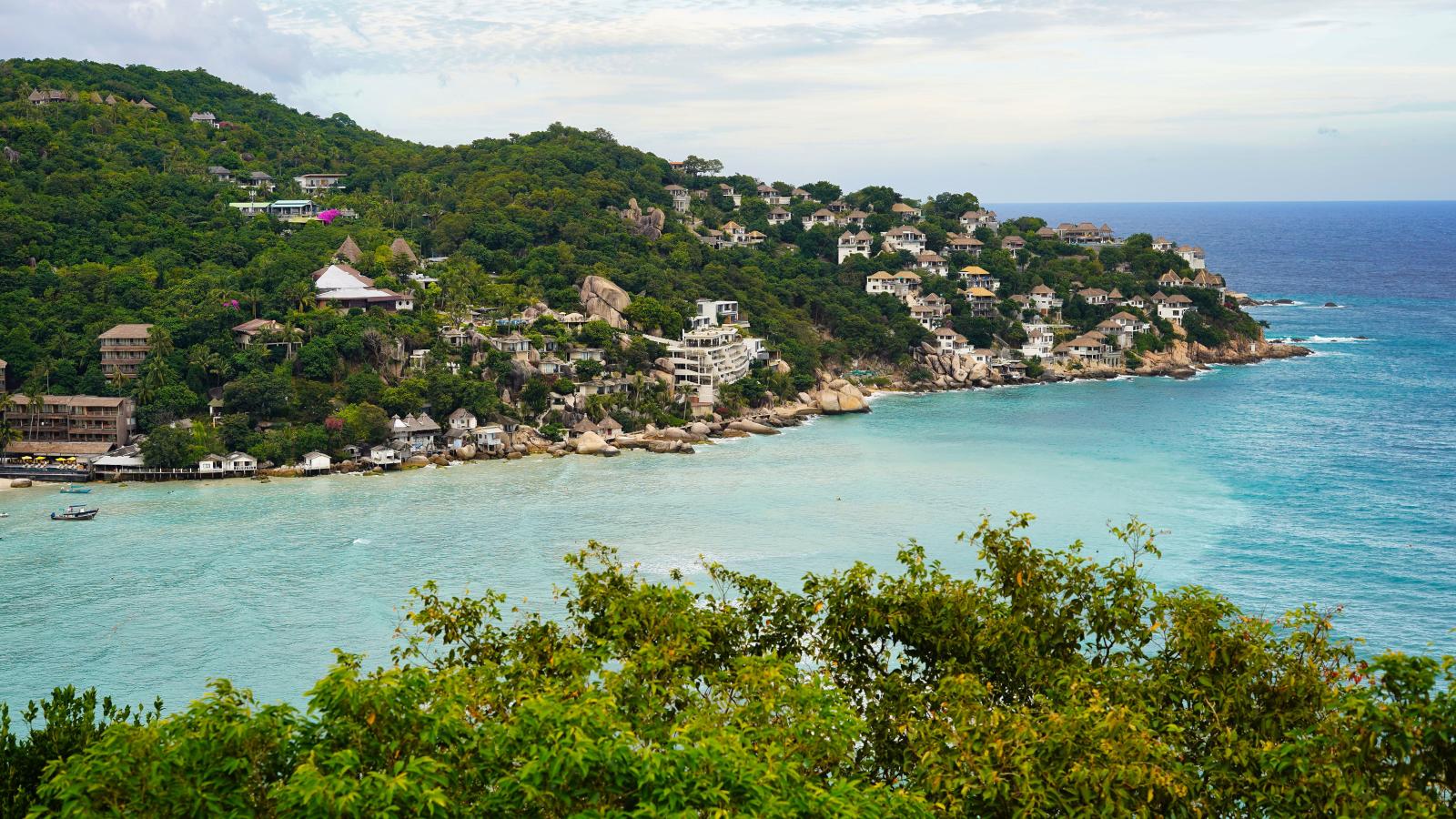 Klare türkisfarbene Bucht mit Felsen und tropischem Grün auf Koh Tao