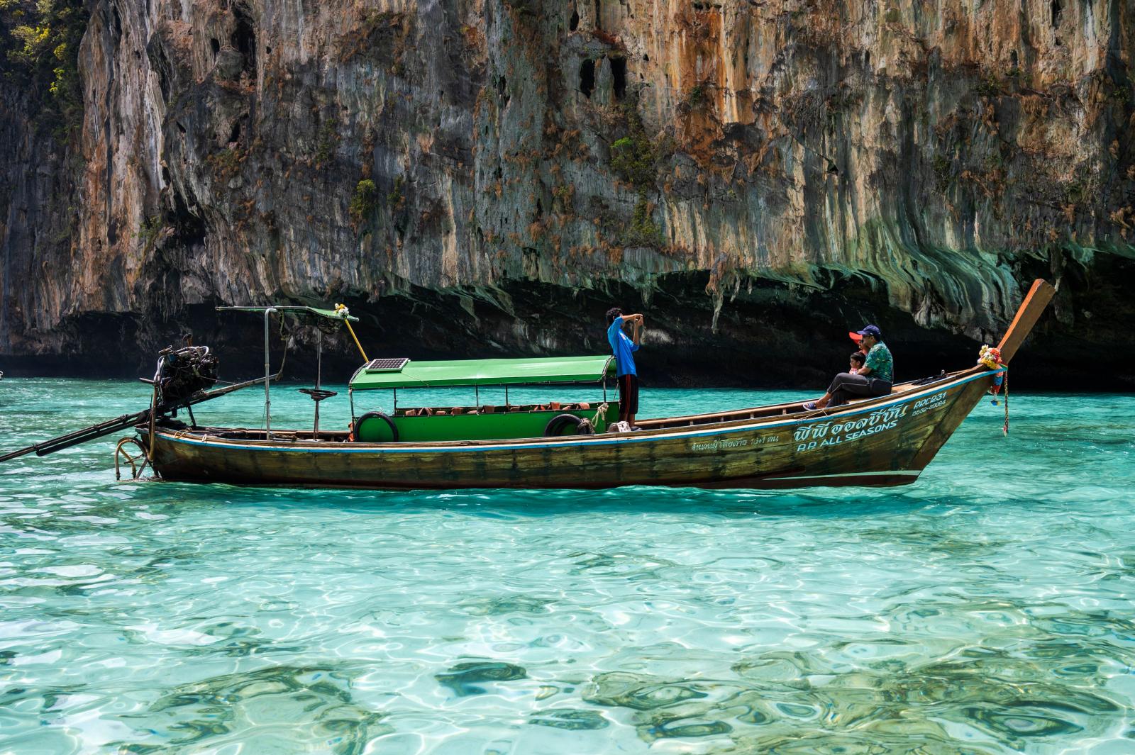 Longtailboot vor den tropischen Felsen der Phi-Phi-Inseln in Thailand
