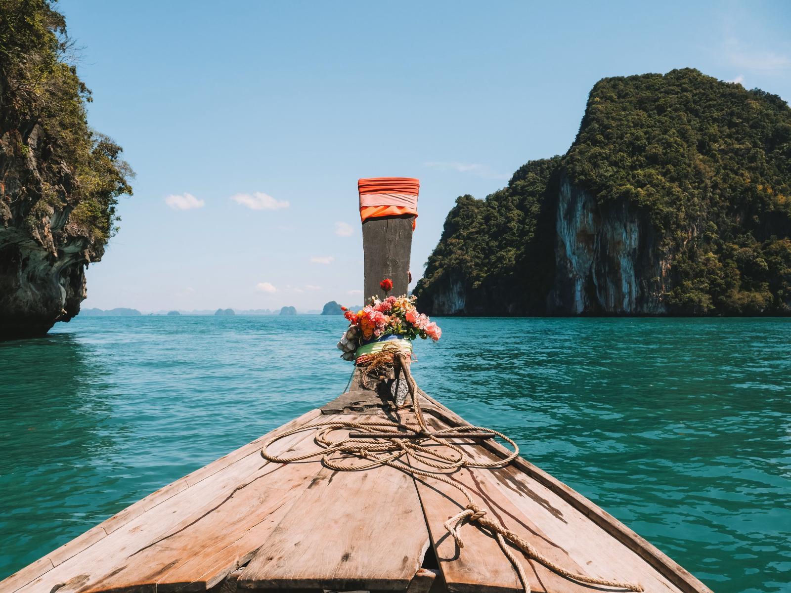 Krabi Ausflüge – Longtailboot vor tropischen Inseln in Thailand.