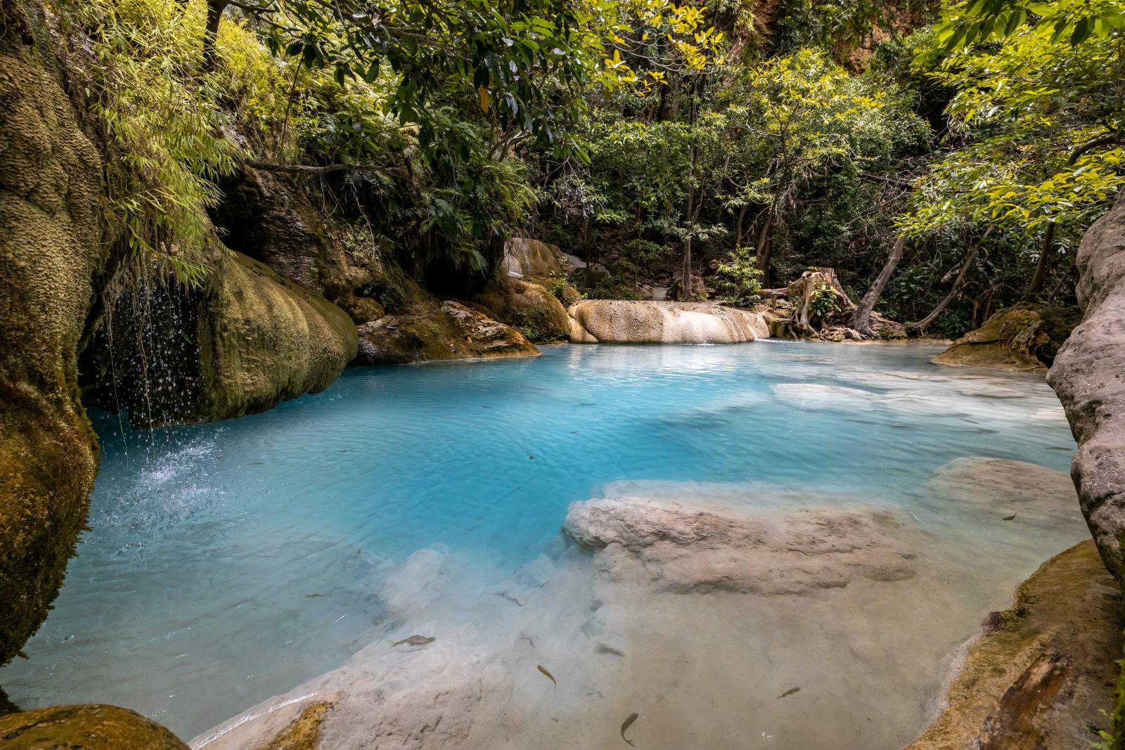 Entdecken Sie die ruhige Schönheit einer türkisfarbenen Lagune, umgeben von üppigem tropischem Wald in Thailand.