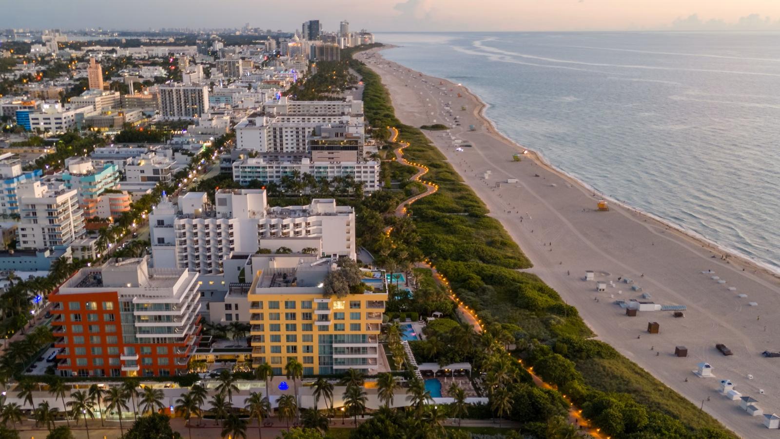 Miami Beach mit Palmen, Sandstrand und Skyline bei Sonnenuntergang