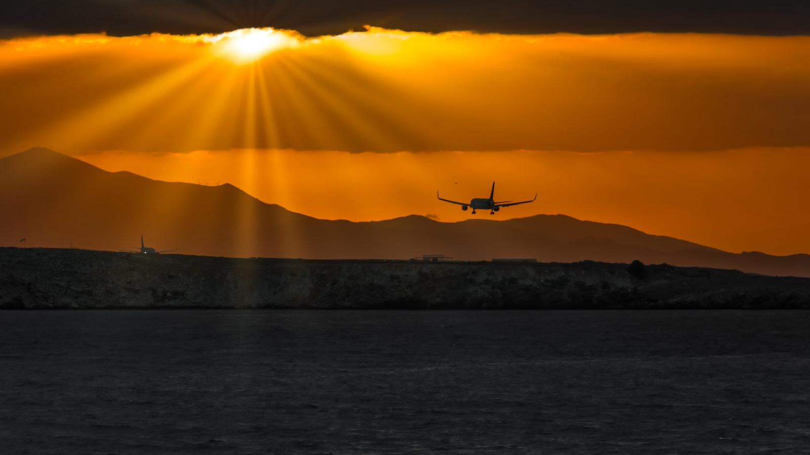 Flugzeug über der mediterranen Küste von Zypern bei Sonnenuntergang