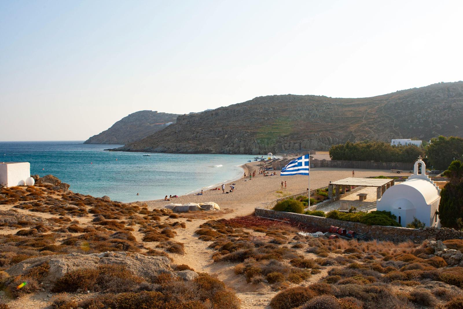 Mykonos Strand mit Kapelle griechischer Flagge und Meer