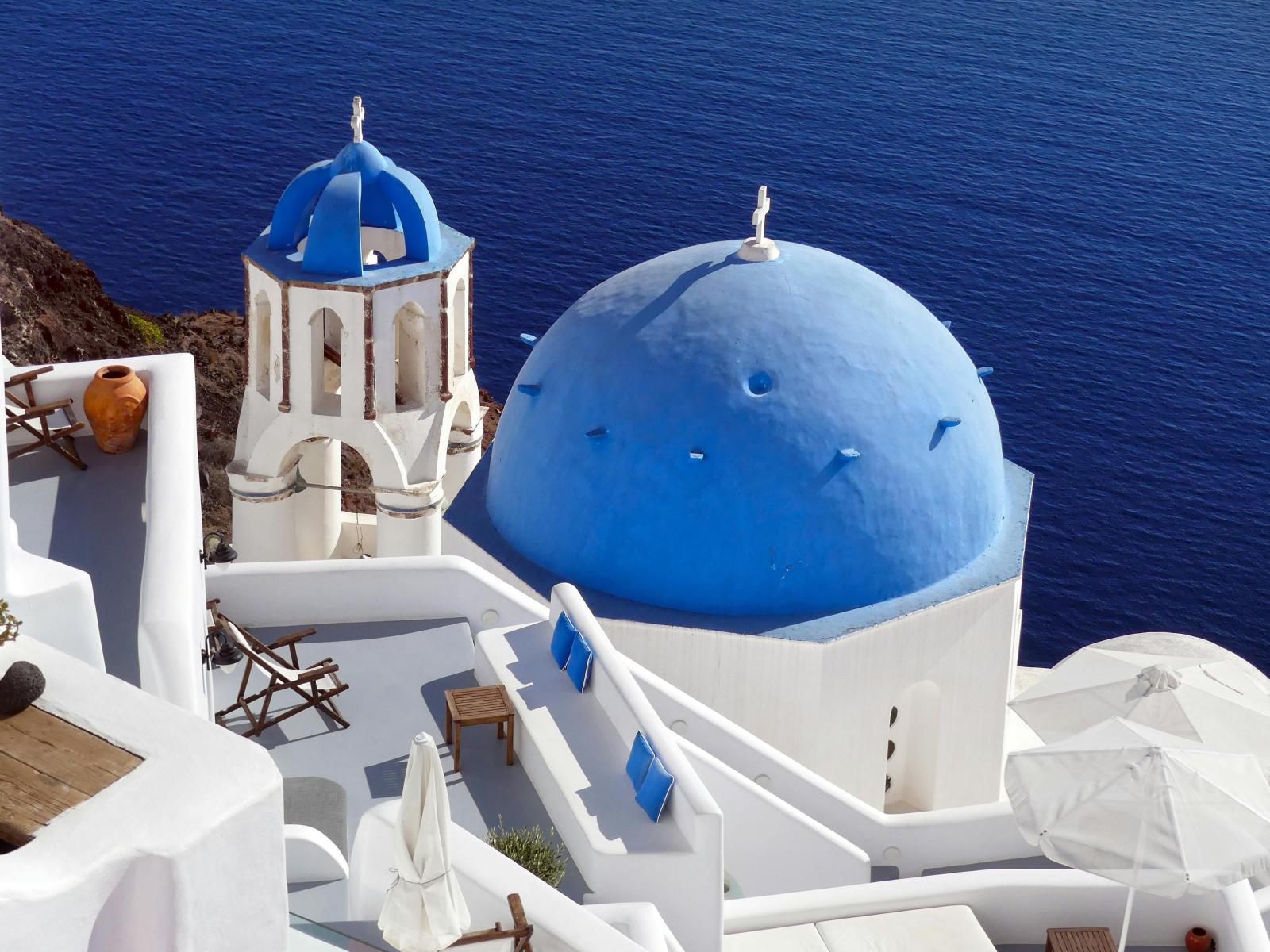 Santorin Urlaub mit blauer Kuppel Kirche und Meerblick
