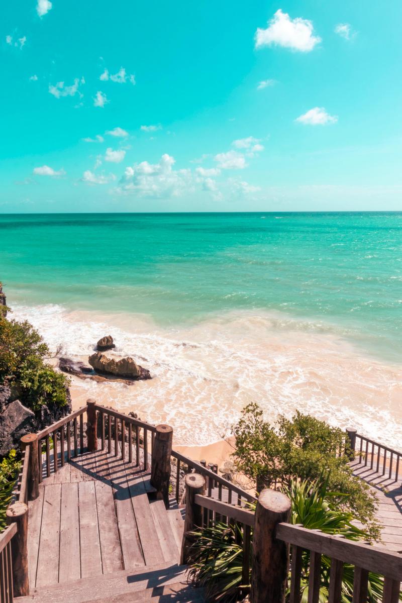 Mexiko Urlaub Küste mit Holztreppe und türkisblauem Meer
