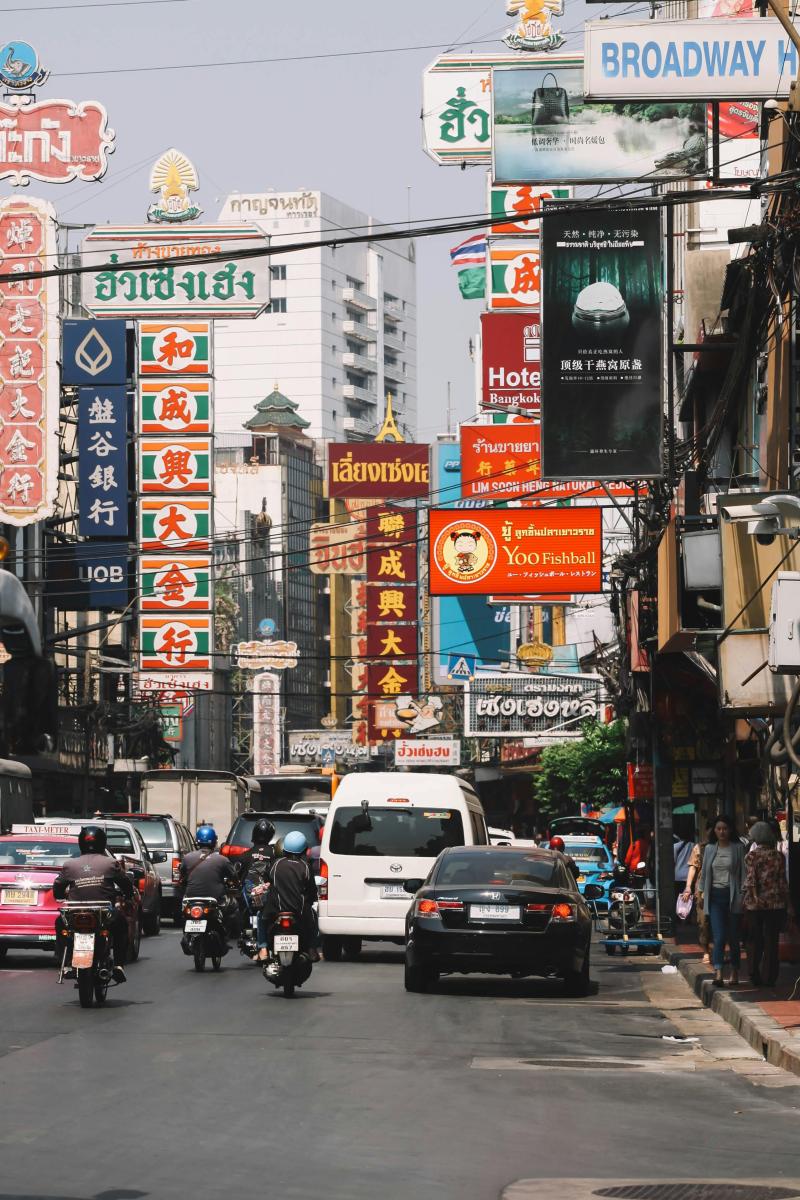 Straßenszene in Bangkok Chinatown mit Verkehr und Schildern