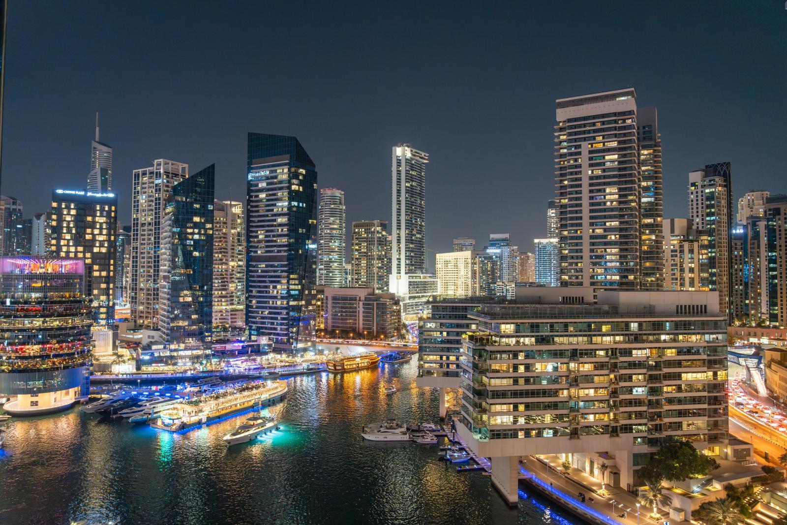 Dubai Marina bei Nacht mit Hochhäusern, Wasser und Lichtern