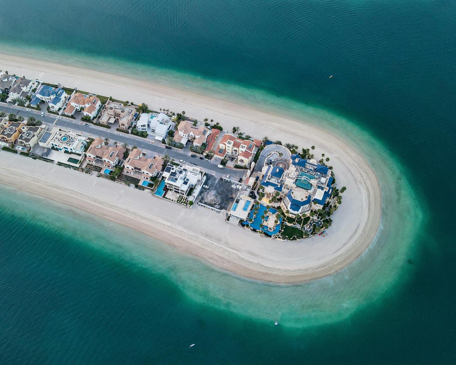 Strand, türkisfarbenes Wasser und moderne Küstenlandschaft in den Vereinigten Arabischen Emiraten