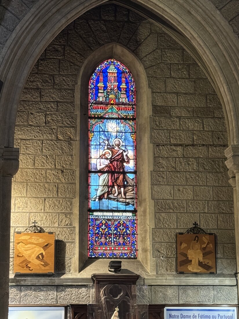 Buntglasfenster mit der Taufe Jesu und einer Taube in der Basilika Notre-Dame in Nizza