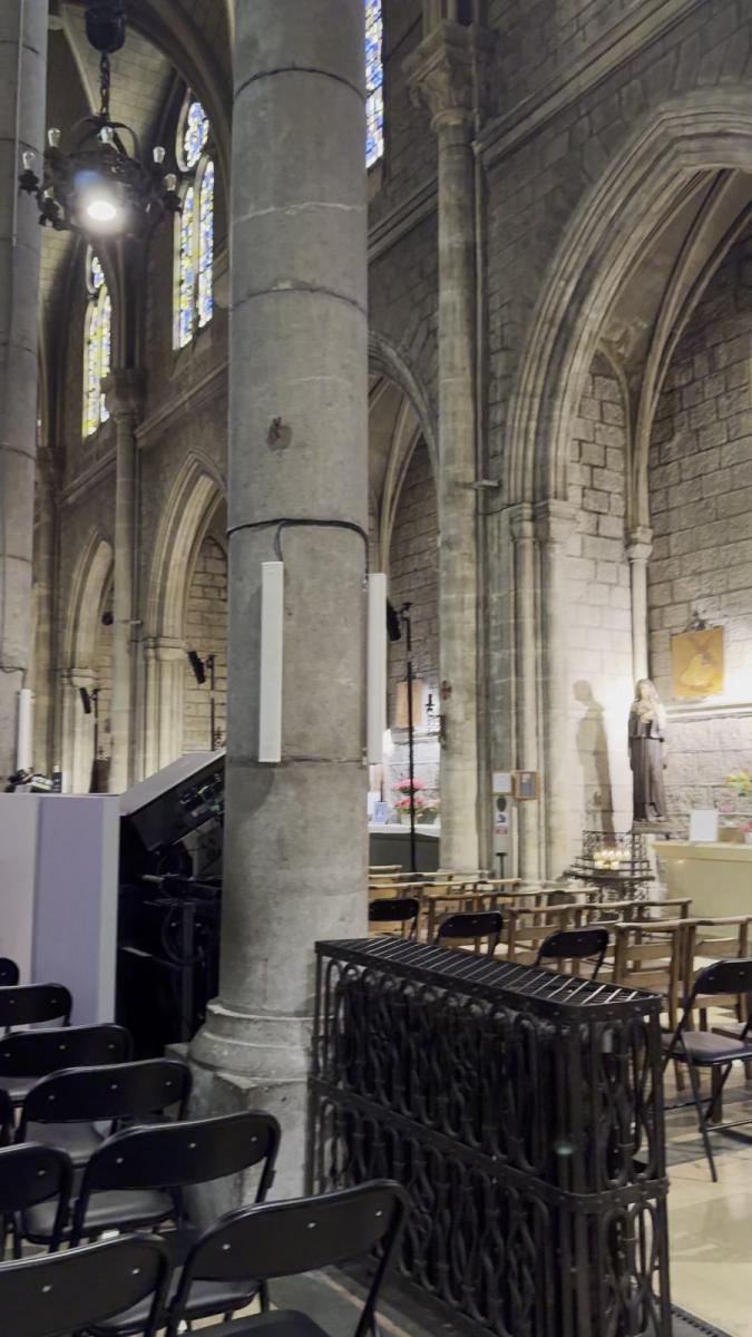 Blick in das hohe Kirchenschiff der Basilika Notre-Dame in Nizza mit Säulen, Gewölben und Buntglasfenstern