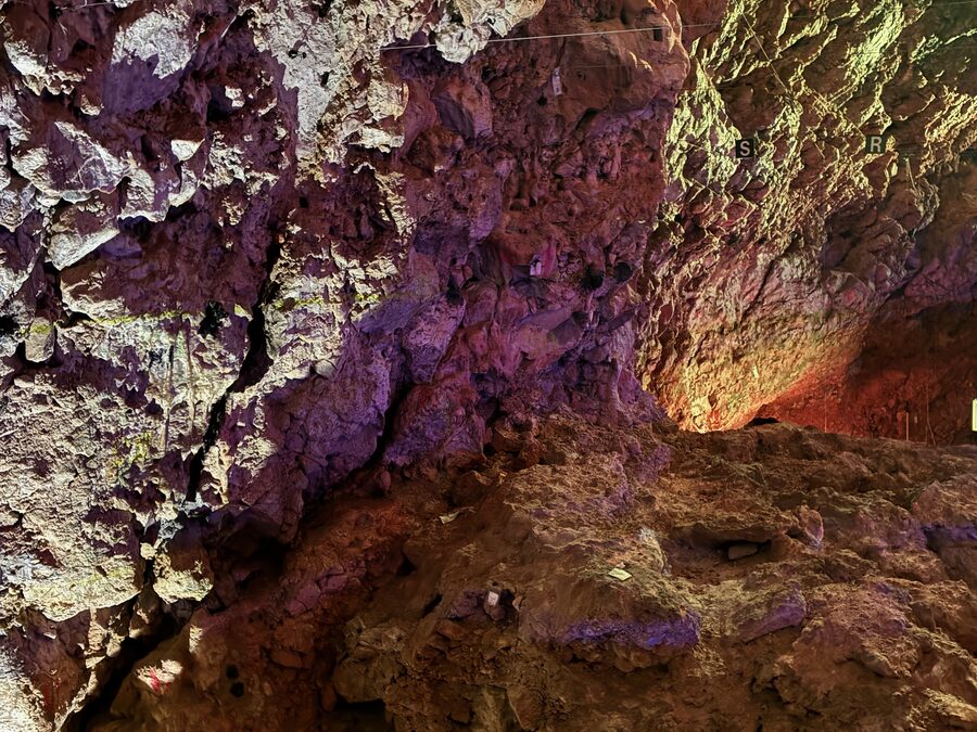 Farbig beleuchteter Fels im Inneren der Grotte du Lazaret in Nizza